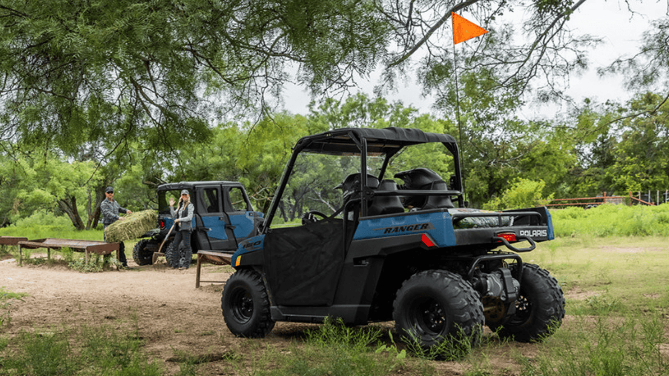 2025 Polaris® Ranger 150 EFI parked outdoors with workers loading hay.