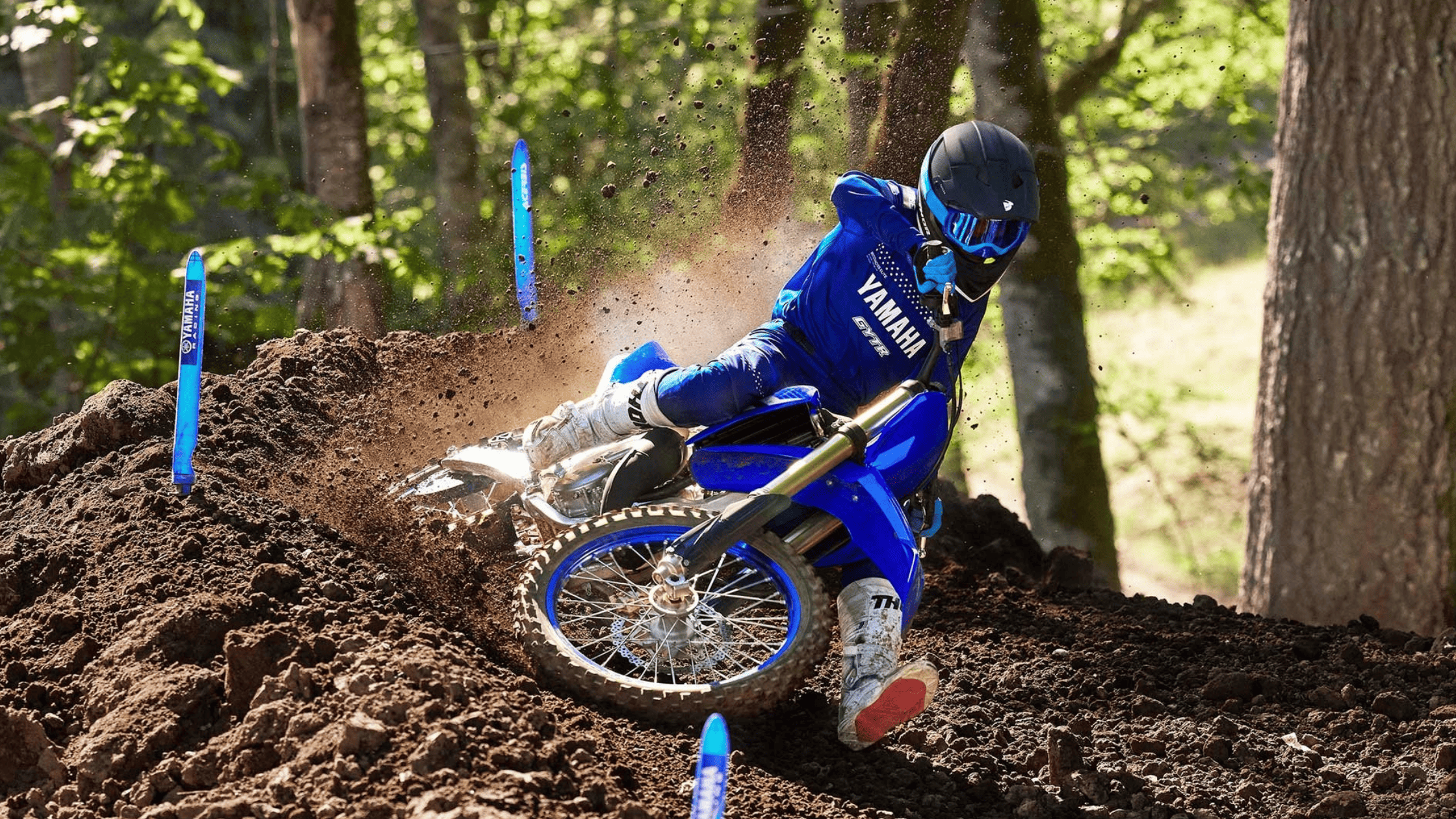 Rider on a blue 2025 Yamaha YZ125 dirt bike leans into a sharp turn.